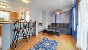A compact living space with a kitchenette, a sofa, two chairs, a coffee table, and a patterned rug. - Pet-friendly Lake Erie Cottage - Walk to the Water (Geneva)