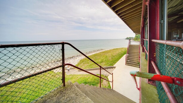 A staircase leading to a beach with a view of the ocean. - Pet-friendly Lake Erie Cottage - Walk to the Water (Geneva)