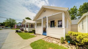 A row of single-story mobile homes with a porch, a sign reading "OPEN," and a small garden area with rocks and shrubs. - Pet-friendly Lake Erie Cottage - Walk to the Water (Geneva)