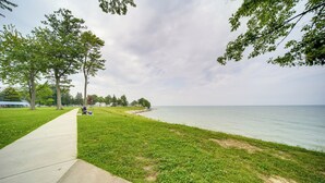 A park with a concrete path, grassy areas, and trees. - Pet-friendly Lake Erie Cottage - Walk to the Water (Geneva)