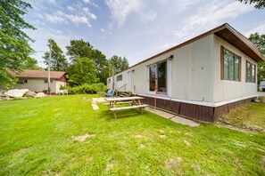 A single-story mobile home with a large deck and picnic table.
