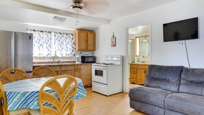 A compact living space with a dining area, kitchenette, and a gray sofa. - Lakefront Geneva Vacation Rental - Walk to Strip! (Geneva)
