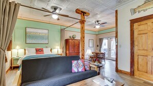 Une pièce comprenant un lit, un canapé, une table en bois et un ventilateur de plafond.