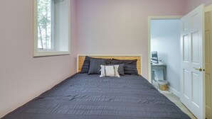 A bedroom with a bed, a window, a desk with a computer, and a door. - Nisswa Lake Getaway w/ Hot Tub + Kayaks! (Nisswa)