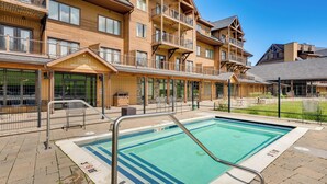 A hotel with a pool area, outdoor seating, and a sign for 'Edmund's Vertical Drop Retail'.