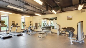 A gym with treadmills, elliptical machines, and weight equipment.