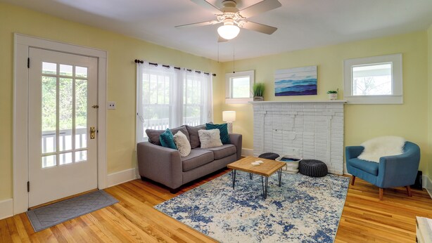A living room with a gray sofa, blue armchair, wooden coffee table, and a patterned rug.