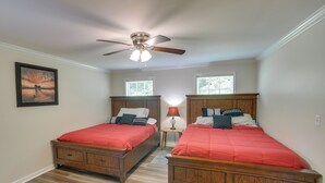A bedroom with two wooden beds, a ceiling fan, and a painting on the wall. - Guntersville Lake House: Dock & Boat Ramp Access! (Scottsboro)