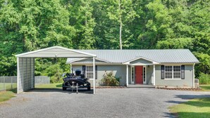 A two-story house with a covered garage and a red door. - Guntersville Lake House: Dock & Boat Ramp Access! (Scottsboro)