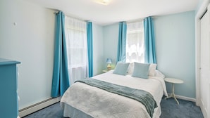 Ein Schlafzimmer mit Bett, Nachttisch und Lampe.
