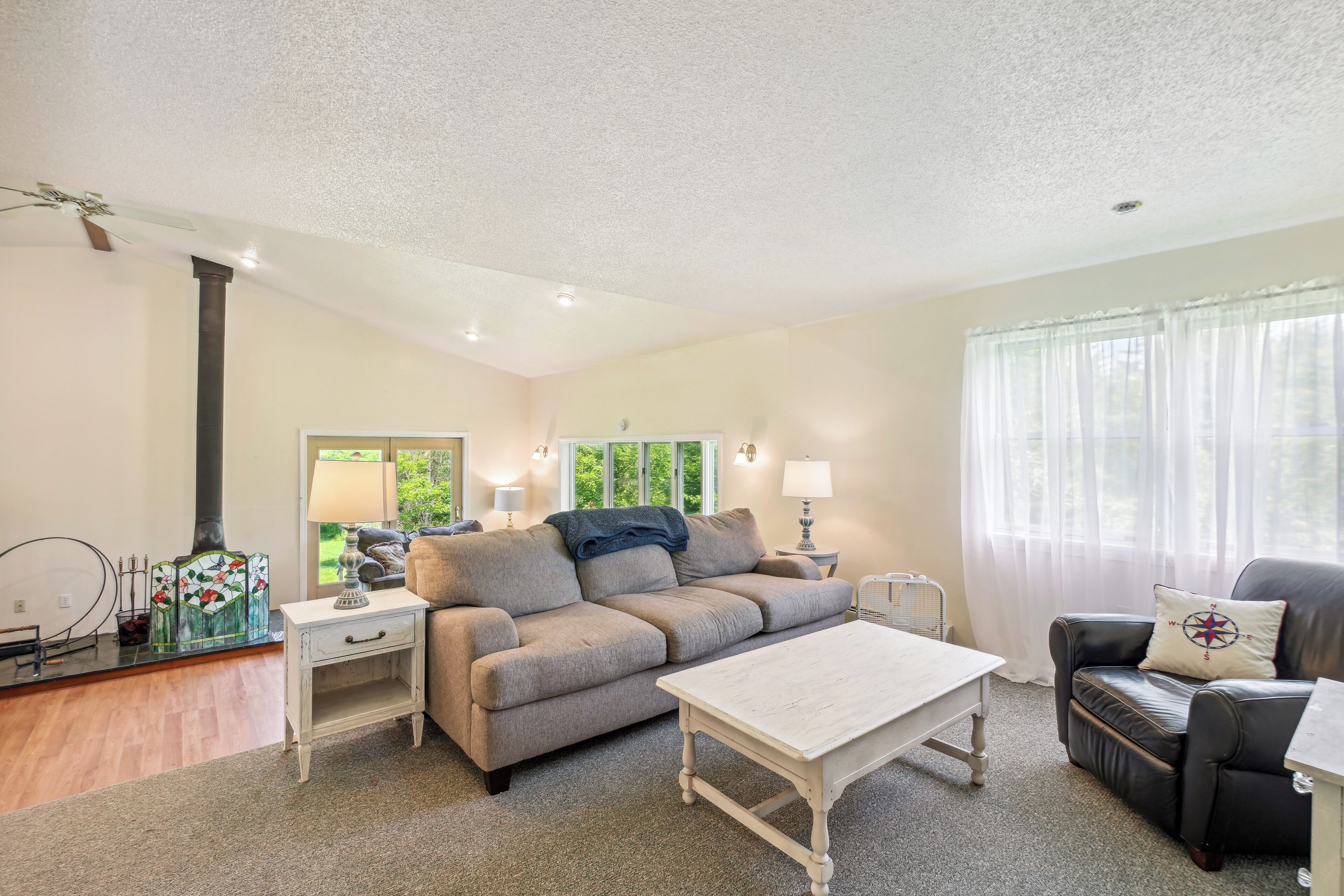 A living room with a sofa, a coffee table, a side table, and a lamp.