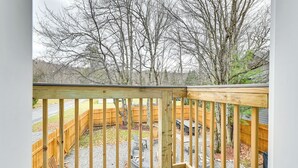 A wooden deck with a view of a backyard, including a wooden fence, trees, and outdoor furniture. - Old Forge Studio: Close to Lakes & Hiking Trails (Old Forge)