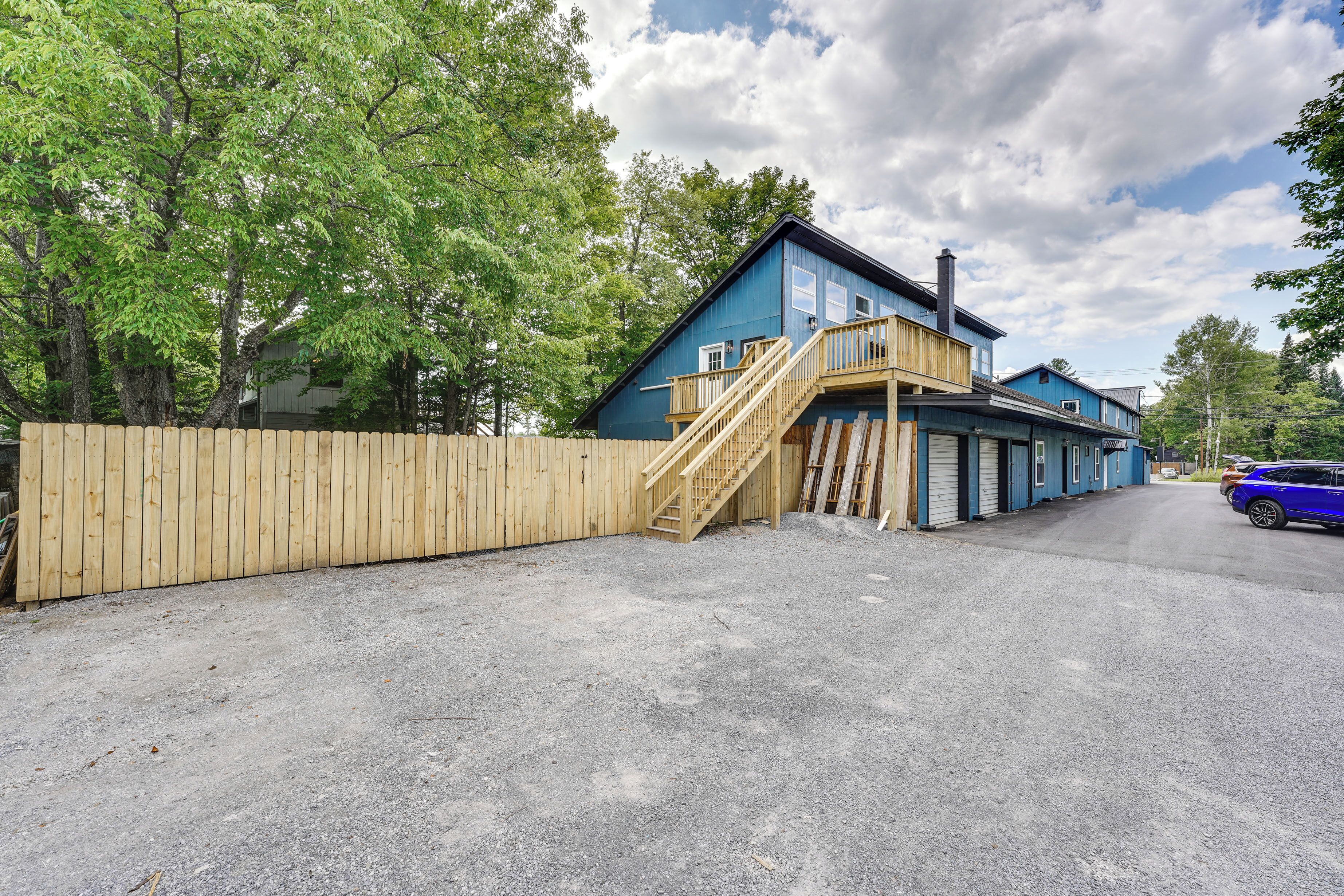 Une maison bleue à deux étages, avec un escalier en bois menant à l’étage supérieur.