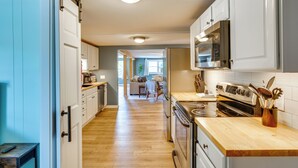 A kitchen with white cabinets, a wooden countertop, and a stove. - Conveniently Located Old Forge Condo Near Downtown (Old Forge)