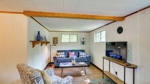 A living room with a sofa, coffee table, and TV stand. - Cozy Becket Cottage Escape w/ Lake Access! (Becket)