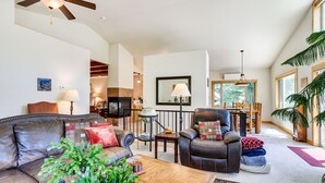 A spacious living room with a leather sofa, a wooden coffee table, and a dining area with a wooden table and chairs. - Mountain Retreat in Drake w/ Fireplace & Views! (Drake)