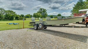 A boat trailer with a boat on it, parked on a gravel surface. - Norfork Studio by White River: Ideal for Fishing! (Norfork)