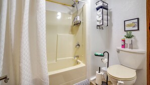 A bathroom with a bathtub, toilet, and shower. - Cozy Great Falls Studio on the Missouri River! (Great Falls)