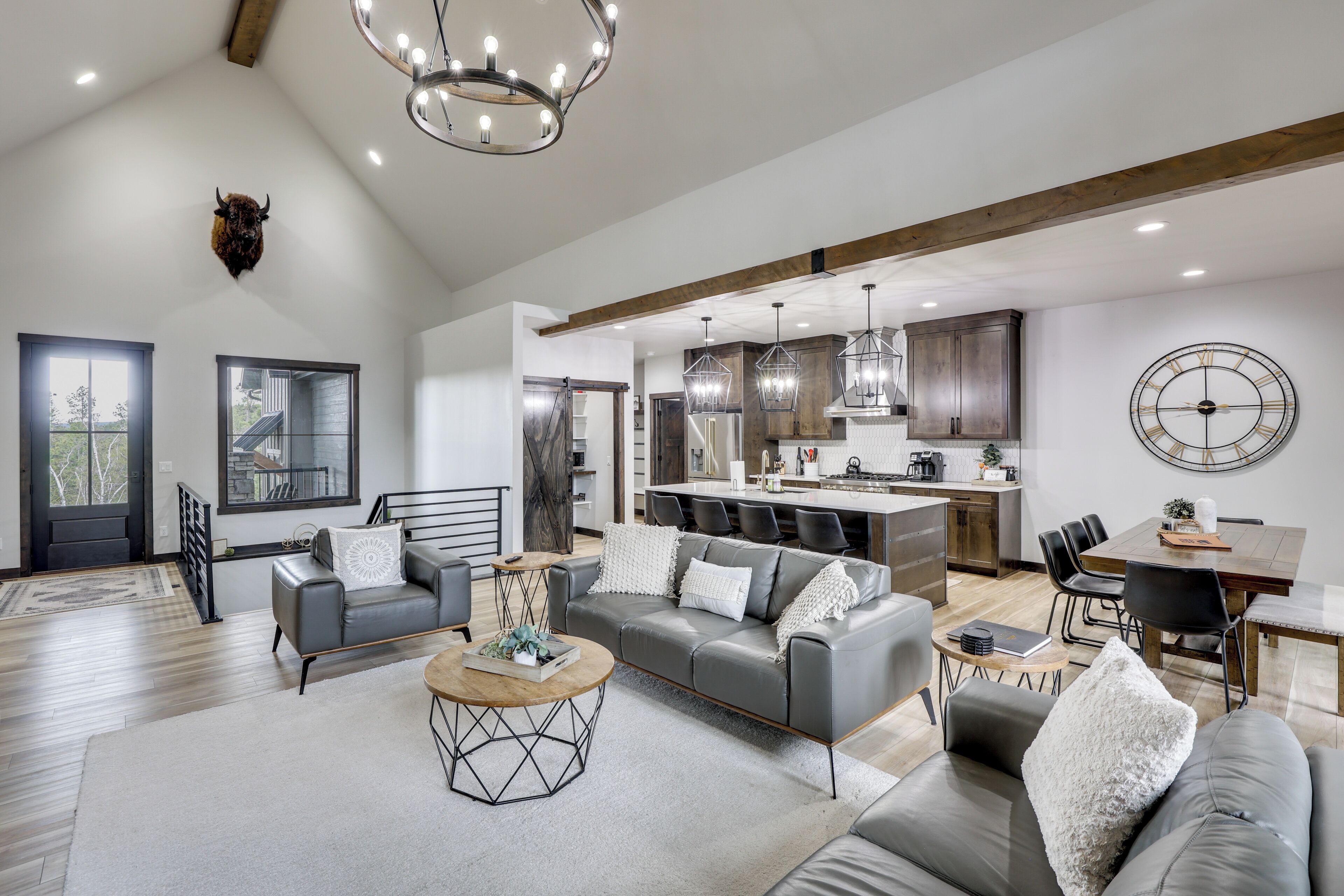 A spacious living area with a grey sofa, coffee table, and dining table.