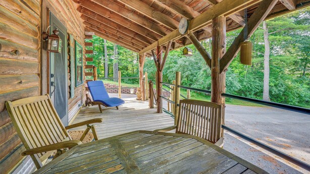 A wooden cabin with a porch, a table, and two chairs. - Charming Wellesley Island Cabin Near State Parks (Wellesley Island)