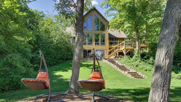 A wooden house with a large deck and a staircase leading to the upper level. - Lakefront Brainerd Cabin w/ Fireplace! (Brainerd)