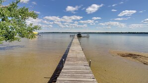 A wooden pier extending into a calm body of water, with a clear sky above. - Lakefront Brainerd Cabin w/ Fireplace! (Brainerd)