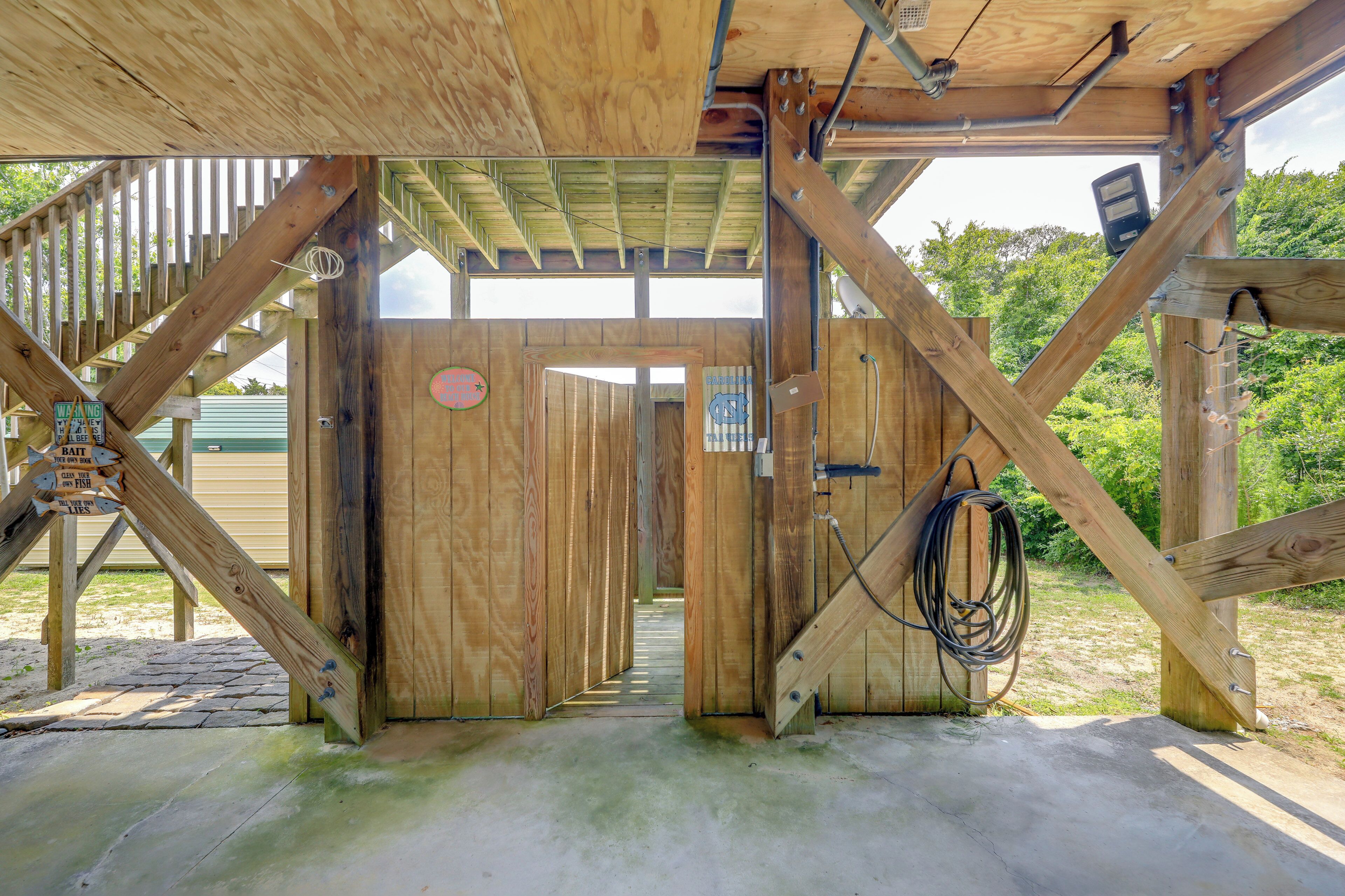 Una struttura in legno con una scala che conduce a una porta, su un pavimento in cemento e con travi in legno.