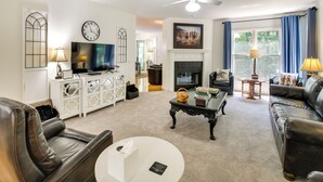 A living room with a fireplace, leather sofas, a television, and a ceiling fan. - Hot Springs Village Golf Getaway w/ Deck! (Hot Springs Village)