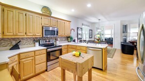 A modern kitchen with wooden cabinets, stainless steel appliances, and a central island with a fruit bowl. - Hot Springs Village Golf Getaway w/ Deck! (Hot Springs Village)