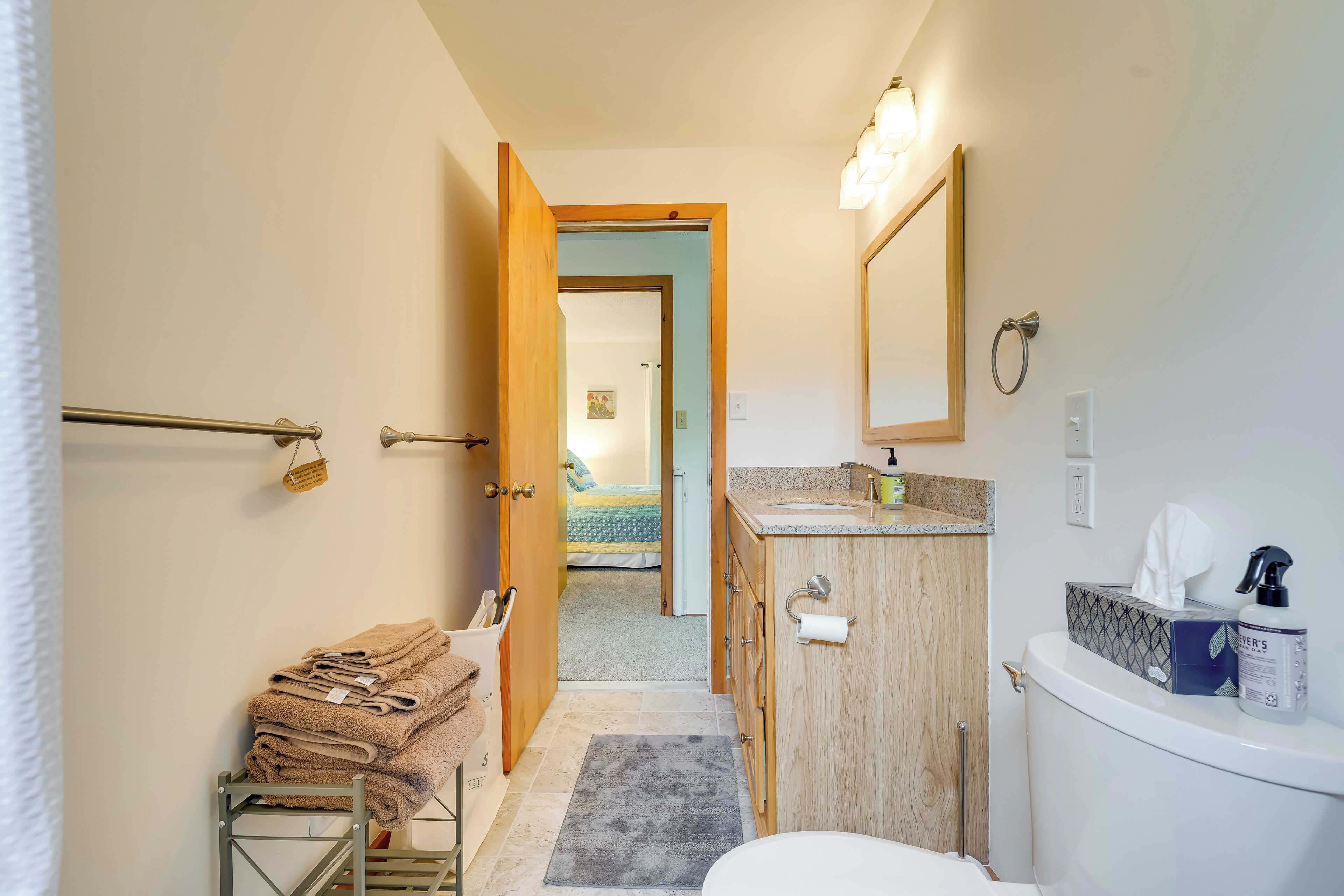 A bathroom with a toilet, sink, and towel rack.