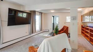 A modern living room with a flat-screen TV, a large window, a fireplace, and a cozy seating area. - 3 Mi to Pioneer Park & University: Spacious Home! (Fairbanks)
