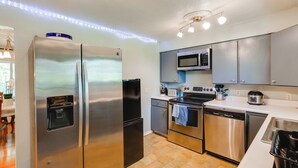 A modern kitchen with stainless steel appliances, a water dispenser, a microwave, and a dishwasher. - 3 Mi to Pioneer Park & University: Spacious Home! (Fairbanks)