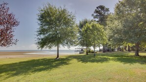A grassy area with trees and a view of the beach.