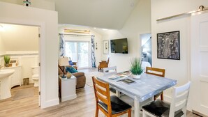 Una cocina moderna con una mesa de comedor, sillas y un televisor montado en la pared.