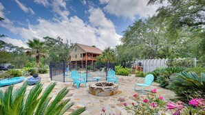 A patio with stone flooring, a fire pit, and blue chairs. - Waterfront Pass Christian Oasis ~ 2 Mi to Beach! (Pass Christian)
