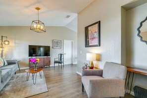 A modern living room with a sofa, armchair, coffee table, and TV. - Florida Vacation Rental w/ Enclosed Porch! (Beverly Hills)