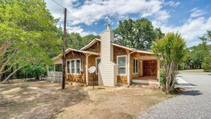 A two-story log cabin with a chimney, large windows, and a porch. - Pottboro Vacation Rental w/ Private Hot Tub! (Pottsboro)