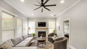 A modern living room with a sofa, armchairs, a coffee table, and a fireplace. - Pottboro Vacation Rental w/ Private Hot Tub! (Pottsboro)