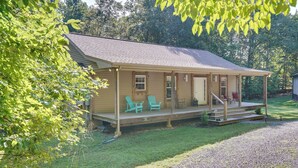 Une maison en bois d’un seul étage, dotée d’un porche, d’un hall d’entrée abrité et d’un petit jardin devant.