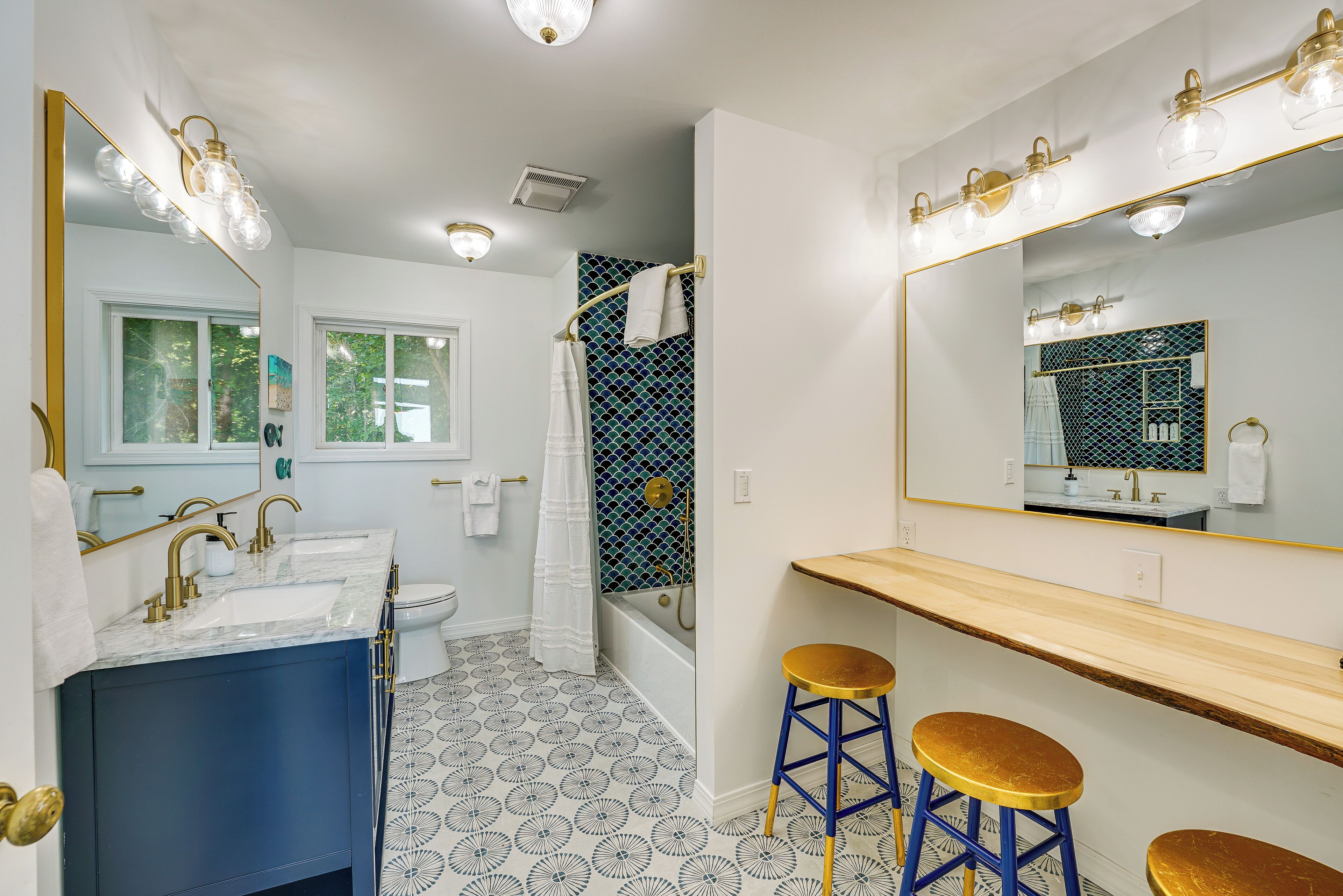 A bathroom with two sinks, a bathtub, and a large mirror.