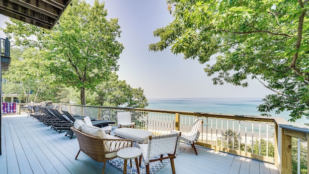 Um terraço com mobiliário externo com vista para a praia.