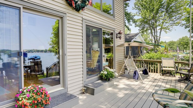 A deck with outdoor furniture, a potted plant, and a view of a lake. - Lakefront Vandalia Home w/ Boat Dock & Gas Grill! (Vandalia)