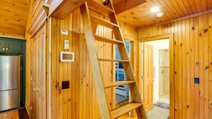 A wooden cabin interior with a wooden ladder, a refrigerator, and a shower area. - Secluded Elka Park Cabin: Hot Tub & Fire Pit! (Tannersville)