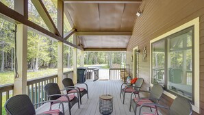 A covered porch with wicker chairs and a small table, surrounded by windows. - 6 Mi to Hunter Mtn: Winter Retreat w/ Hot Tub! (Tannersville)