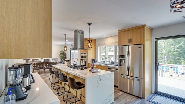 A modern kitchen with a central island, stainless steel appliances, and a view to the outdoors. - 6 Mi to Hunter Mtn: Winter Retreat w/ Hot Tub! (Tannersville)