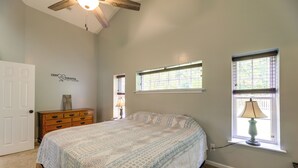 A bedroom with a bed, dresser, two windows with blinds, a ceiling fan, and a wall decoration. - Swansboro Vacation Rental, 4 Mi to Hammocks Beach! (Swansboro)