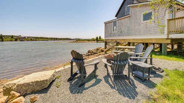 A lakeside cabin with outdoor seating and a deck overlooking the water. - Historic Winter Harbor Cottage w/ Waterfront Views (Winter Harbor)