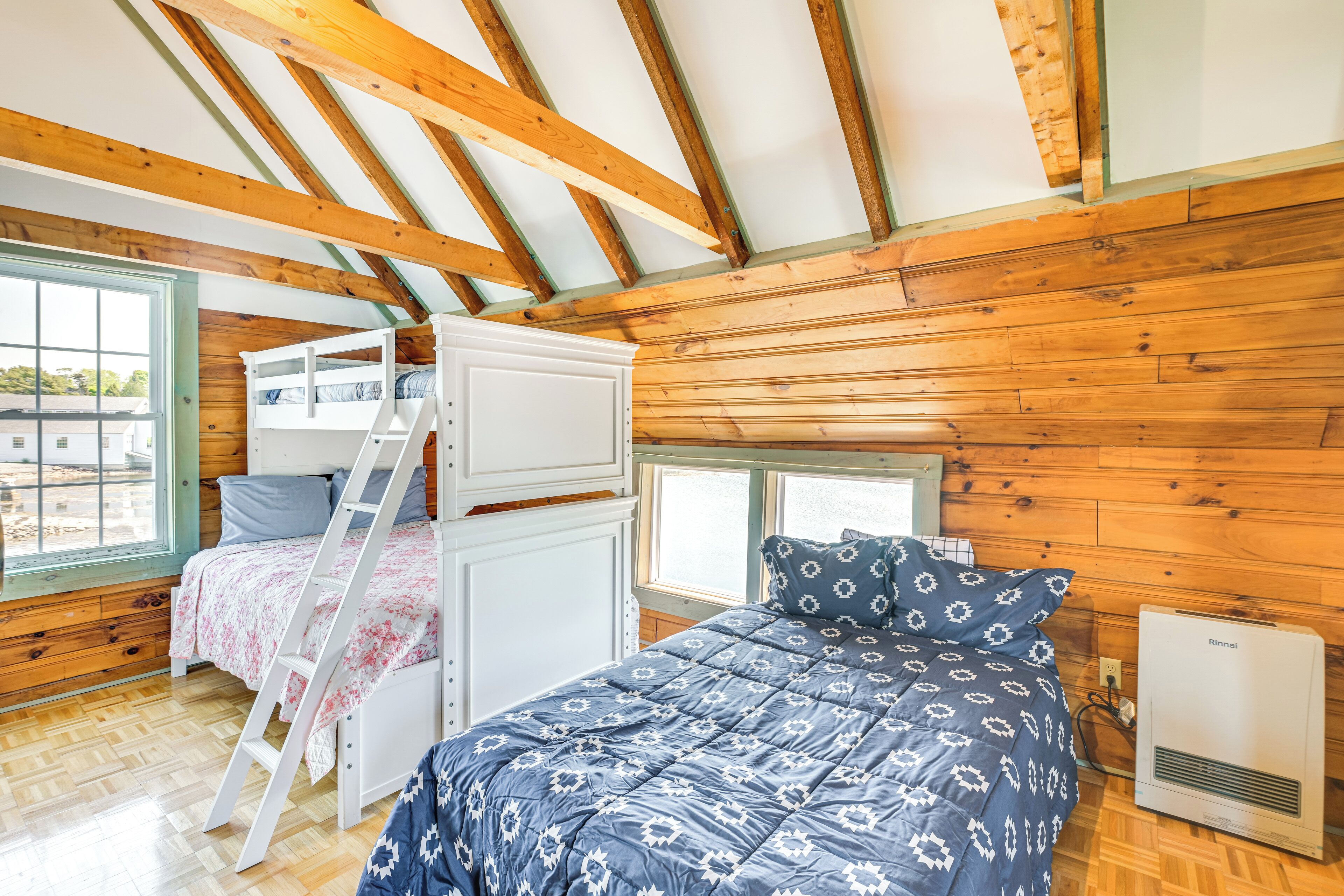 Une cabine équipée d’un lit superposé, d’une échelle, d’une fenêtre et d’un radiateur fixé au mur.