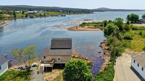 A riverside property with a house, dock, and boats. - Historic Winter Harbor Cottage w/ Waterfront Views (Winter Harbor)