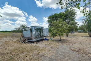 Ein stehendes Krankenwagenfahrzeug in einem trockenen, offenen Feld mit vereinzelter Vegetation und blauem Himmel.